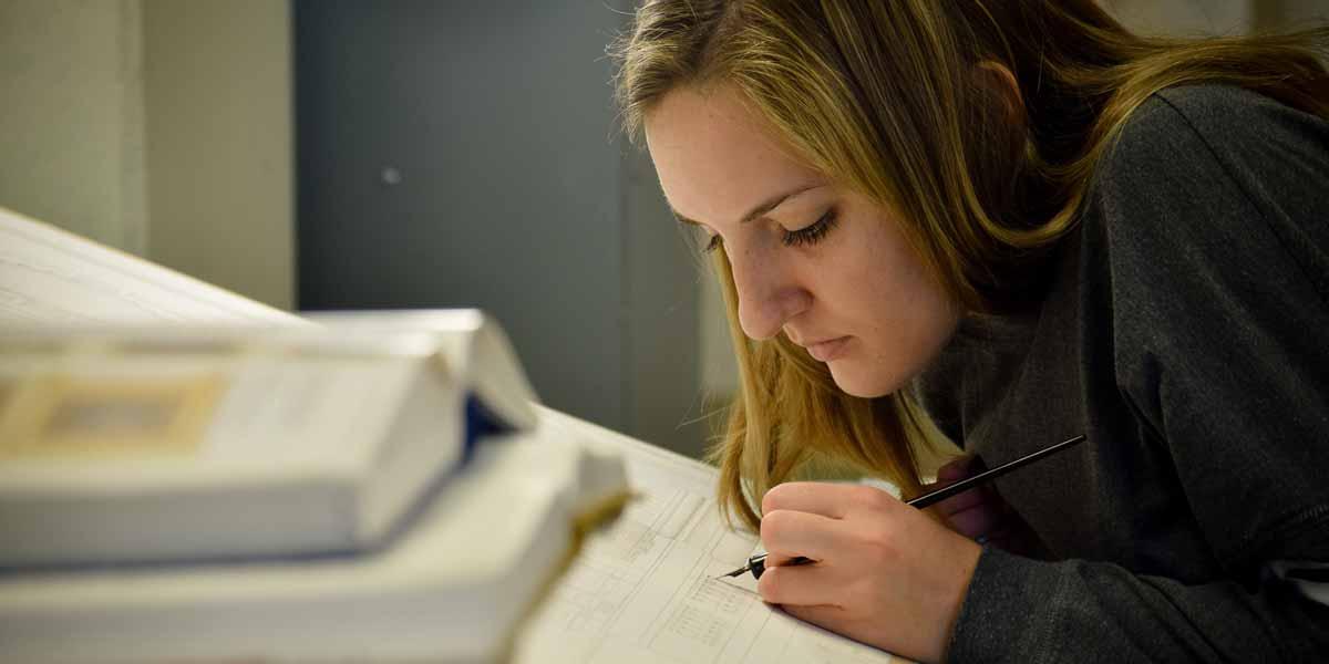 A student at a drafting table in Architecture class